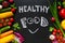 Healthy food concept with fresh vegetables for cooking.Title `Healthy food` with smile is written by chalk on the background