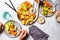 Healthy food concept. Vegan dinner flat lay. People hands eating baked vegetables sweet potato and cauliflower with avocado and