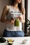 Healthy food concept with young woman holding green avocado smoothie, lifestyle, faceless