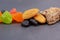 Healthy food. Dried fruits: nuts, raisins, almonds, multi-colored candied fruits, a piece of chocolate on a gray background