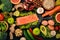 Healthy food. Fish salmon, avocado, broccoli, fresh vegetables, nuts and fruits. On a black background.