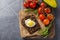 Healthy food flatlay. Vegetables on wooden serving board. Tomatoes. Fried egg. Bread. Avocado. Top view.