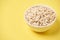 Healthy food. Muesli for breakfast. Bowl with flakes. Yellow background