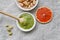 Healthy food, pistachio paste, peeled and unpeeled salted pistachios, grapefruit, wooden spoon on a light background. Components