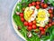 Healthy food on a plate. Rucola, avocado with egg, cherry tomatoes, blue onion. Vegetarian lunch.