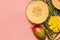 Healthy food, tropical fruits, mango, melon on a monstera leaf with smoothies on a pink background, space for text flat lay