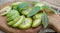 healthy food. Walnuts, cut into slices, are scattered on a cutting board. Old vintage table and whole unripe walnut