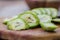 healthy food. Walnuts, cut into slices, are scattered on a cutting board. Old vintage table and whole unripe walnut fruit