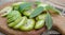 healthy food. Walnuts, cut into slices, are scattered on a cutting board. Old vintage table and whole unripe walnut fruit