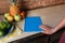 Healthy Food. Woman Hand on blue notebook, kitchen table with pineapple and fruit