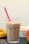 Healthy fresh smoothie drink from red apple, banana chia seeds and plant protein powder in the glass with straw