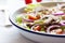 Healthy fresh summer salad with letucce, radish, cherry tomatoes, red onion and champignons with italian herbs on a table