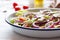 Healthy fresh summer salad with letucce, radish, cherry tomatoes, red onion and champignons with italian herbs on a table