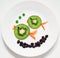 Healthy and fun food for kids on white plate