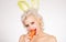 Healthy girl with nibbles a carrot like a hare. Vegan easter bunny eating healthy carrot. Happy easter and spring
