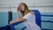 Healthy girl resting after hard training and drinking water standing on boxing ring in gym