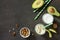 Healthy green cocktail with avocado and walnuts in a bank of glass on dark stone background.