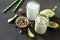 Healthy green cocktail with avocado and walnuts in a bank of glass on dark stone background. Yogurt cocktail.