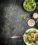 Healthy green diet salad with chicken , Pine nuts and olive oil dressing on dark rustic background, top view, border. Healthy ea