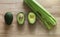 Healthy green fresh ingridients for smoothie cooking. Avocado, avocado in a section and celery on the wooden table