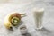 Healthy green smoothie made from banana, kiwi and chia seeds next to the ingredients. Vitamin delicious breakfast recipe