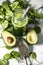 Healthy green smoothie with spinach in a bottle with spinach leaves and fresh avocado