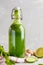 Healthy green vegetable detox smoothie in a glass bottle. Vegan