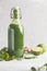 Healthy green vegetable detox smoothie in a glass bottle. Vegan