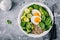 Healthy green vegetarian buddha bowl lunch with eggs, quinoa, spinach, avocado, grilled brussels sprouts and broccoli