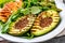 Healthy grilled chicken, grilled avocado and asparagus salad with linen seeds. Balanced lunch in bowl. Gray slate