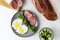 Healthy hearty American breakfast scrambled eggs fried ham eggs and bread on a gray plate on a white background top view