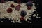 healthy hearty tasty oatmeal with berries and fruits raspberry blackberry apple on a black kitchen board on a dark