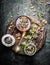 Healthy herbal tea preparation with fresh healing herbs, cup and vintage tea strainer on dark rustic wooden background