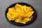 Healthy Homemade banana Plantain Chips on black plate, slate background