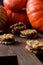 Healthy homemade dessert. Pumpkin oatmeal breakfast cookie sandwiches with chocolate and winter squashes on oak board