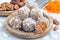 Healthy homemade paleo energy balls with carrot, nuts, dates and coconut flakes, on wooden plate, horizontal