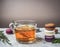 Healthy hot herbal tea with berries, thyme and mint, appetizing, multicolored macaroons, piled on white rustic background, space