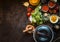 Healthy ingredients for tasty tomato soup: tomatoes, fresh herbs, spices, tinned tomatoes on dark rustic kitchen table with cast