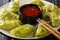 Healthy Japanese food green dumplings gyoza with matcha with sauce and microgreen close-up on a plate. horizontal