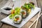 Healthy kale and avocado sushi roll with chopsticks
