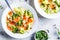 Healthy kids alphabet soup with broccoli, carrot and potato in white plates, top view