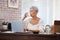 A healthy life makes for a long life. a senior woman using a laptop and drinking water at home.