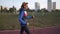 Healthy lifestyle concept. Mature caucasian woman doing cardio exercise walking with sticks or nordic walking on stadium