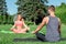 Healthy Lifestyle. Couple practicing yoga outdoors sitting in lotus pose on yoga mats doing meditation woman looking