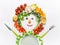 Healthy lifestyle and dieting concept. Friendly Man made of salad vegetables , plate, cutlery and measuring tape on white desk
