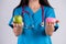 Healthy lifestyle, food and sport concept. Healthy versus unhealthy. Doctor woman hand holding donut and green apple