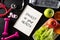 Healthy lifestyle, food and sport concept. Top view of Stethoscope measuring tape pink dumbbell, sport water bottles, fruit and