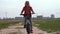 Healthy lifestyle - girl riding a bicycle across the field near the city