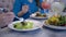 Healthy lifestyle, girls on diet eats greek salad from white plates sitting at table in cafe