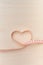 Healthy lifestyle - Measuring tape wrapped in a heart shape isolated on wooden background. Top view. Copy space. Vertical shot